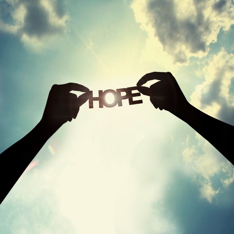 Holding paper cut of hope Show the paper cut word in the sky